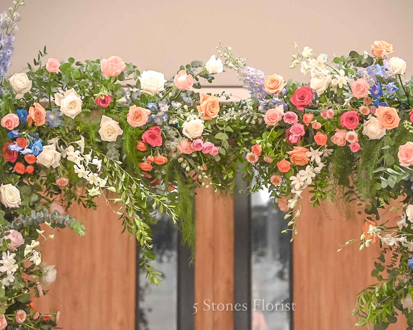 Colourful spring wedding floral arch at Grace Baptist Church entrance by 5 Stones Florist