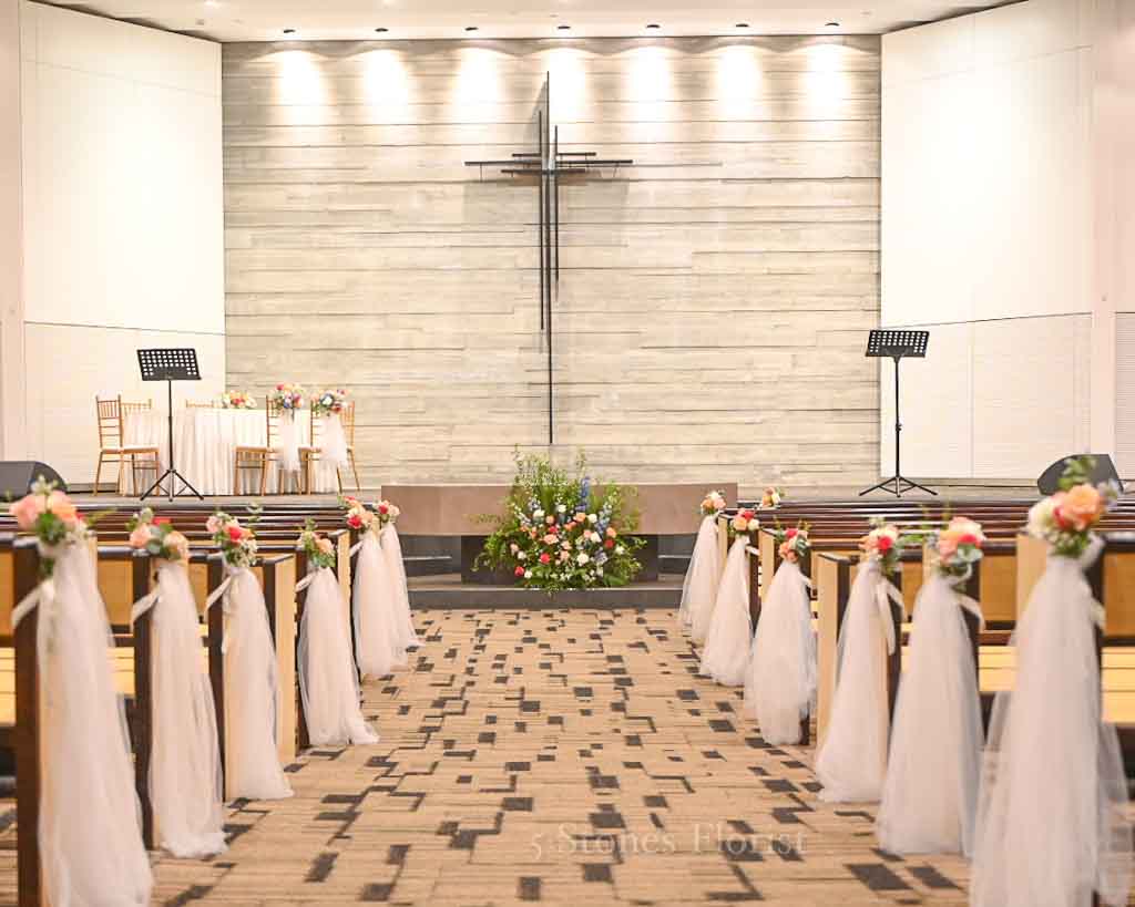 Pew posies with white sashes for a spring church wedding ceremony